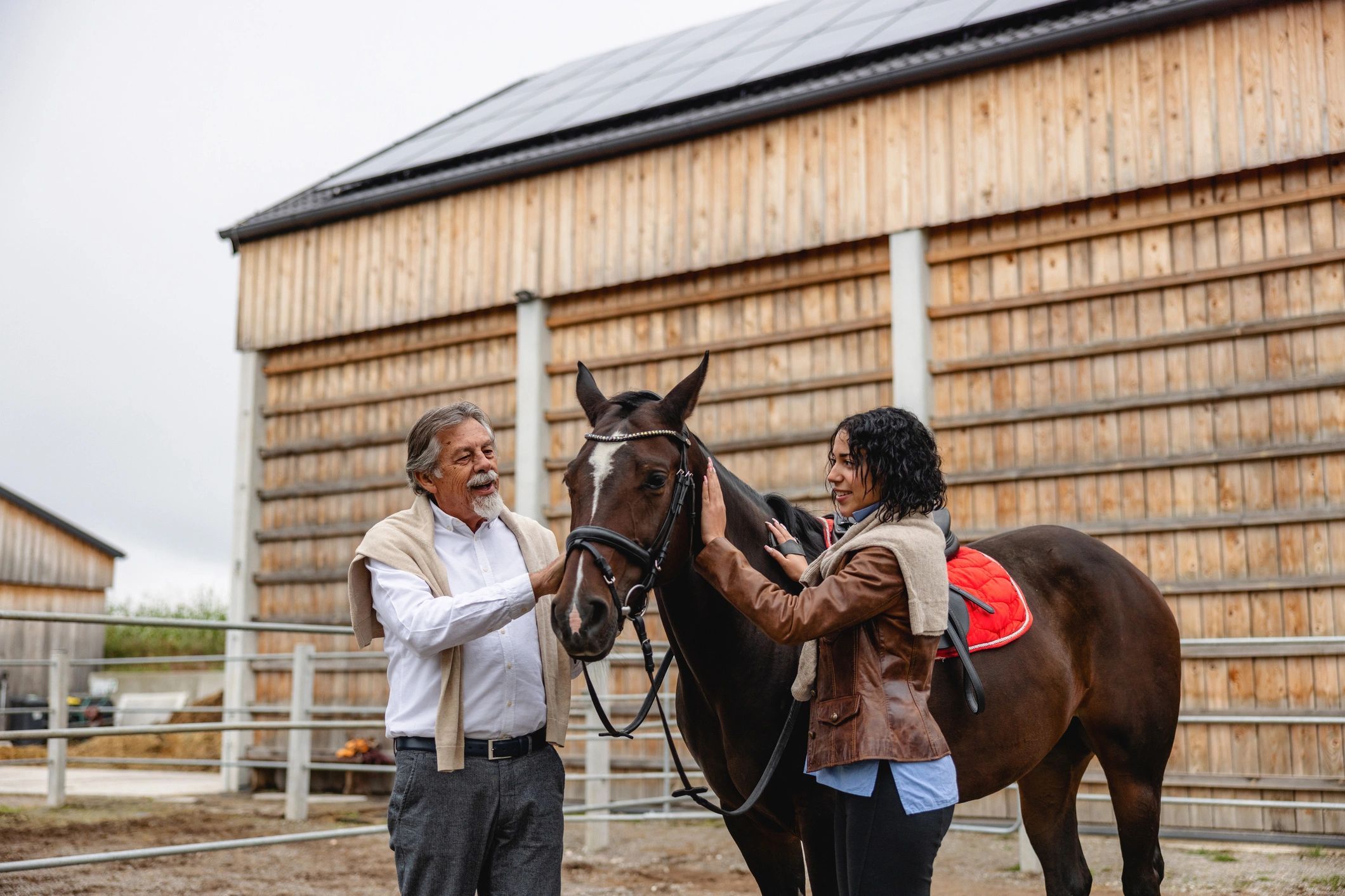 A grandparent showing a child around a barn